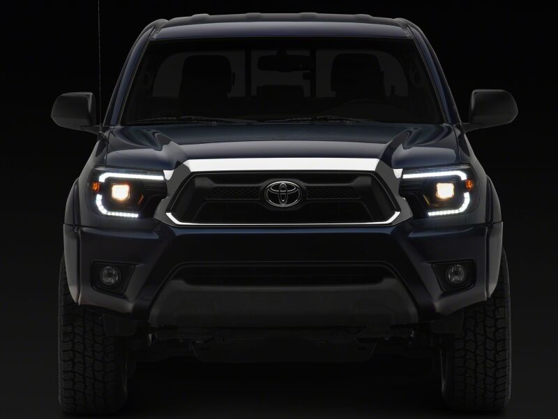 Raxiom 12-15 Toyota Tacoma Axial Series Switchback Projector Headlights- Black Housing- Clear Lens
